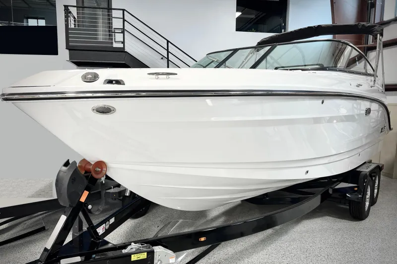 The Image of 2024 Sea Ray SLX 260 boat on trailer in showroom setting. - 0
