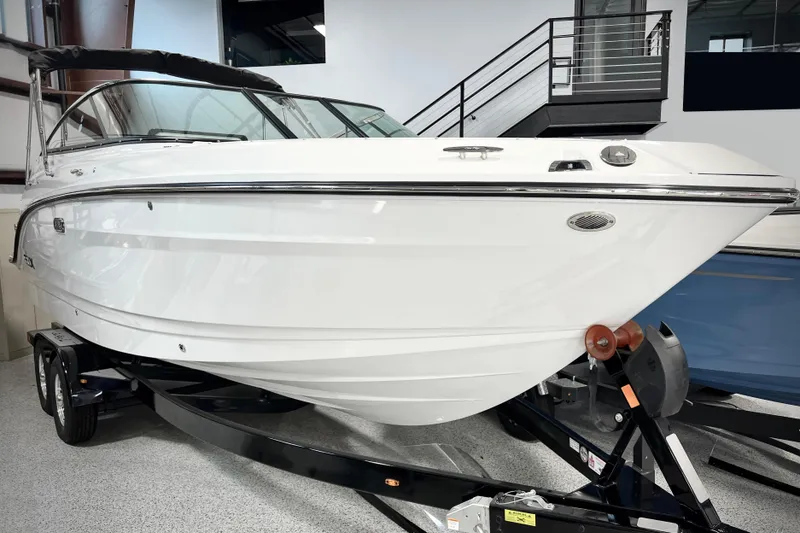 Slide: The Image of 2024 Sea Ray SLX 260 boat on trailer, sleek white design, indoor showroom. - 1
