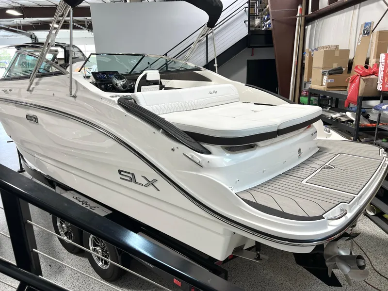 Slide: The Image of 2024 Sea Ray SLX 260 boat in showroom, featuring sleek design and spacious seating. - 21