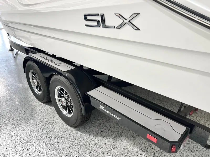 Slide: The Image of 2024 Sea Ray SLX 260 boat on trailer, showcasing sleek design and dual wheels. - 23