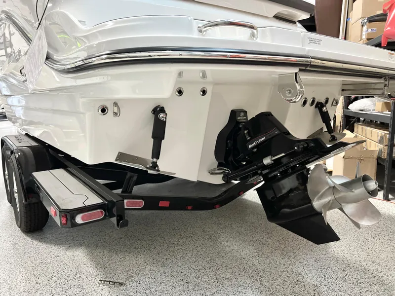 Slide: The Image of 2024 Sea Ray SLX 260 boat stern with propeller and trailer in a showroom. - 24