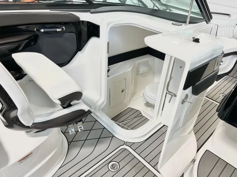 Slide: The Image of 2024 Sea Ray SLX 260 boat interior with seating and compact restroom. - 41