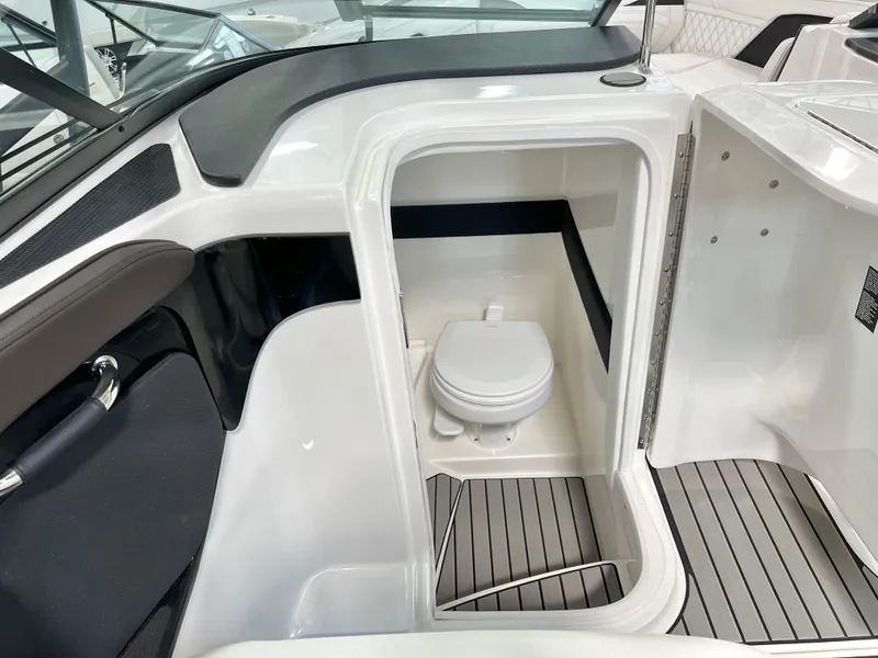 Slide: The Image of 2024 Sea Ray SLX 260 boat interior with compact marine toilet and sleek design. - 43
