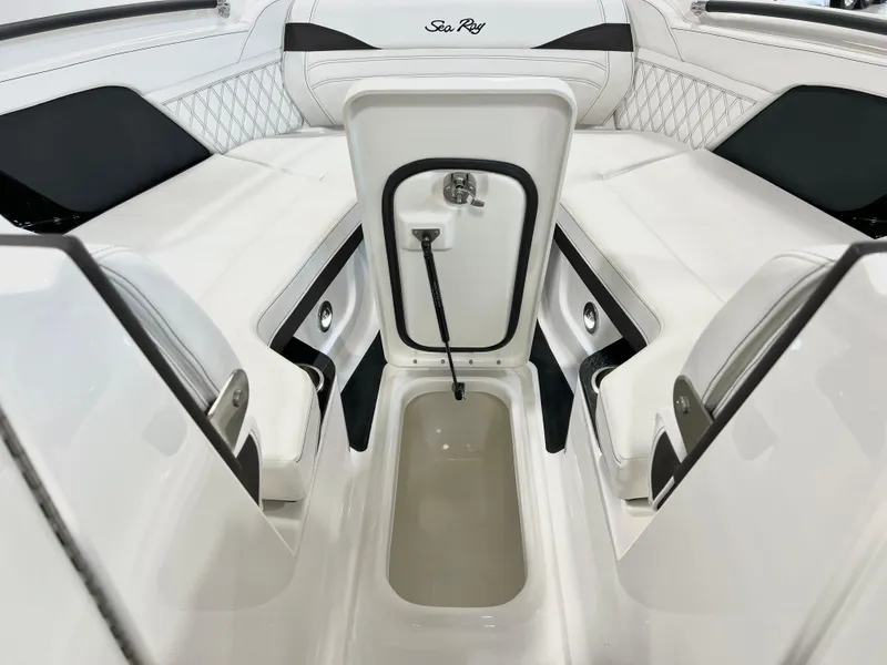Slide: The Image of 2024 Sea Ray SLX 260 boat interior with open storage compartment, white seating, and elegant design. - 49