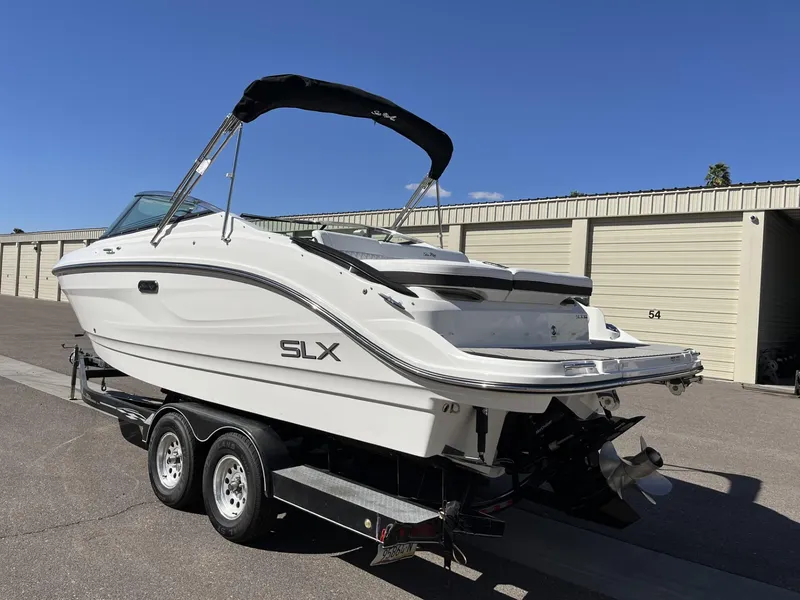 Slide: The Image of 2024 Sea Ray SLX 260 boat on a trailer in a storage facility. - 54