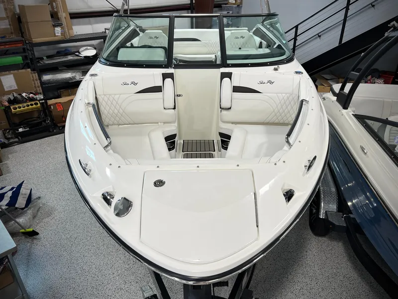 Slide: The Image of 2024 Sea Ray SLX 260 boat with sleek white design and spacious seating. - 6