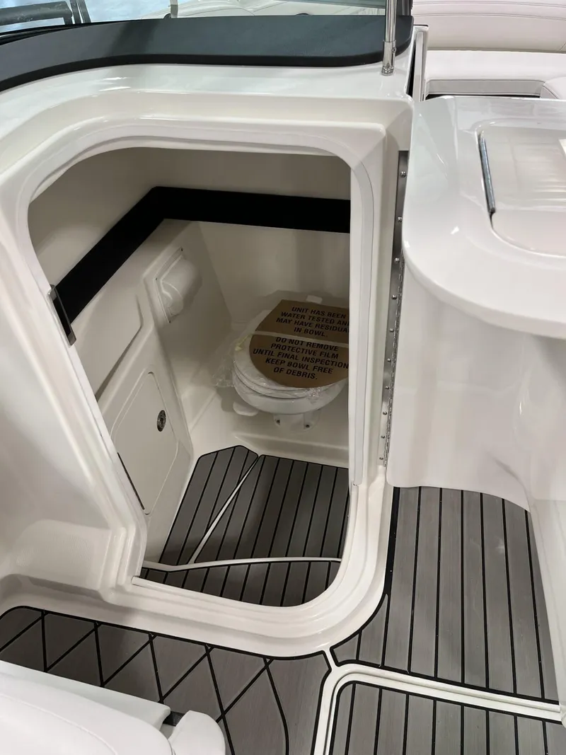 Slide: The Image of 2024 Sea Ray SLX 260 boat interior with built-in toilet and modern flooring. - 66