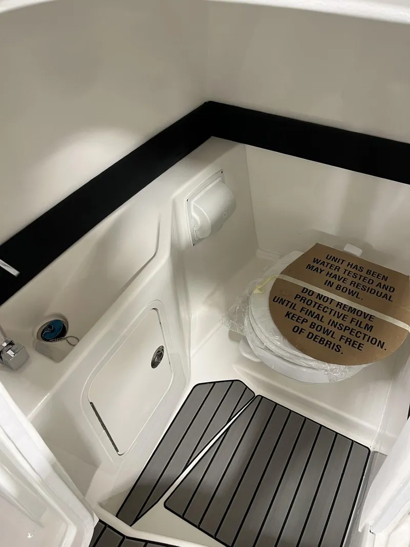 Slide: The Image of 2024 Sea Ray SLX 260 boat interior with toilet and storage compartment. - 67