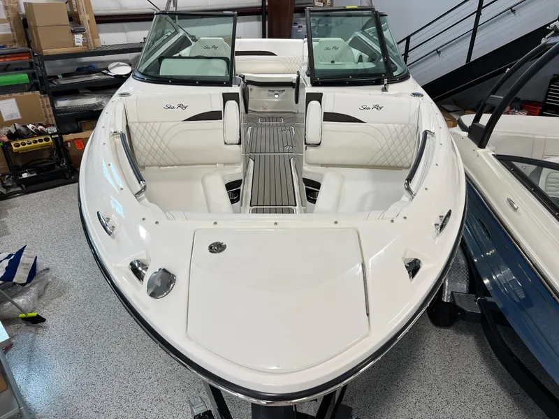 Slide: The Image of 2024 Sea Ray SLX 260 boat with sleek white design in showroom. - 7