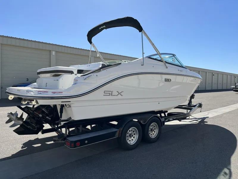 Slide: The Image of 2024 Sea Ray SLX 260 boat on a trailer in a storage facility. - 81