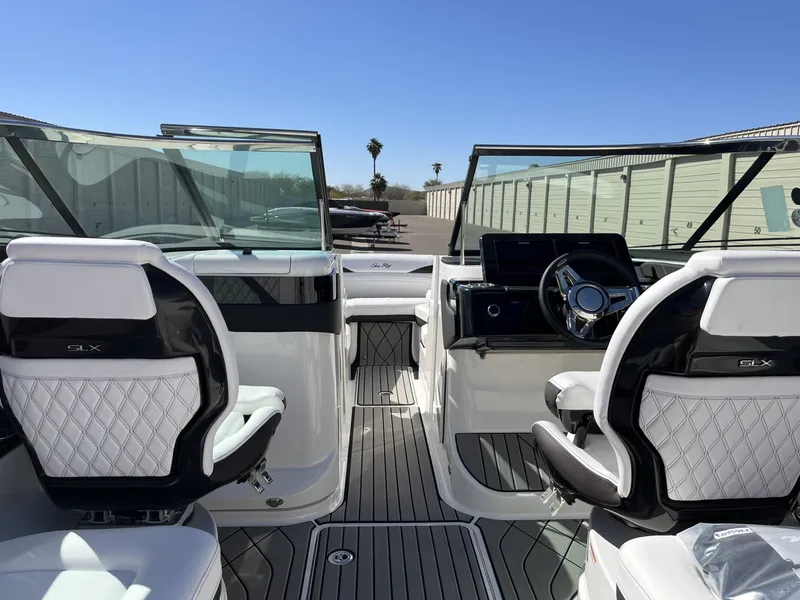 Slide: The Image of 2024 Sea Ray SLX 260 boat interior with dual captain's chairs and modern dashboard. - 85