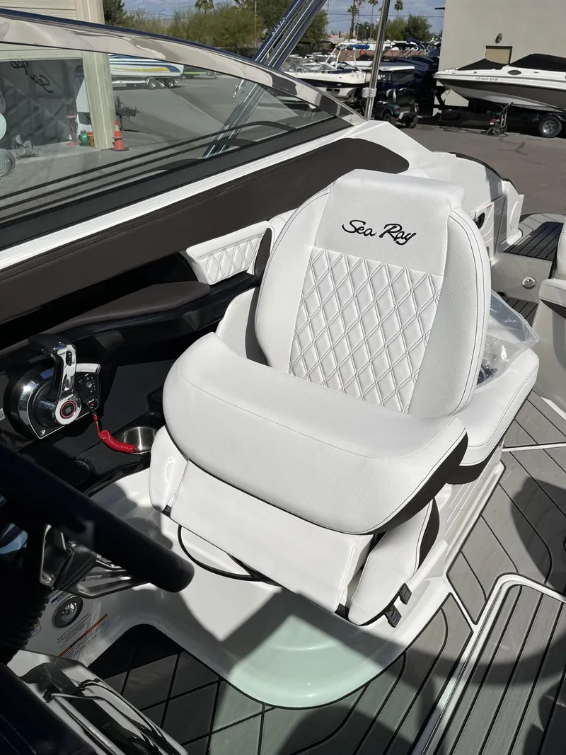 Slide: The Image of 2024 Sea Ray SLX 260 boat with luxurious white captain's seat and modern dashboard. - 87