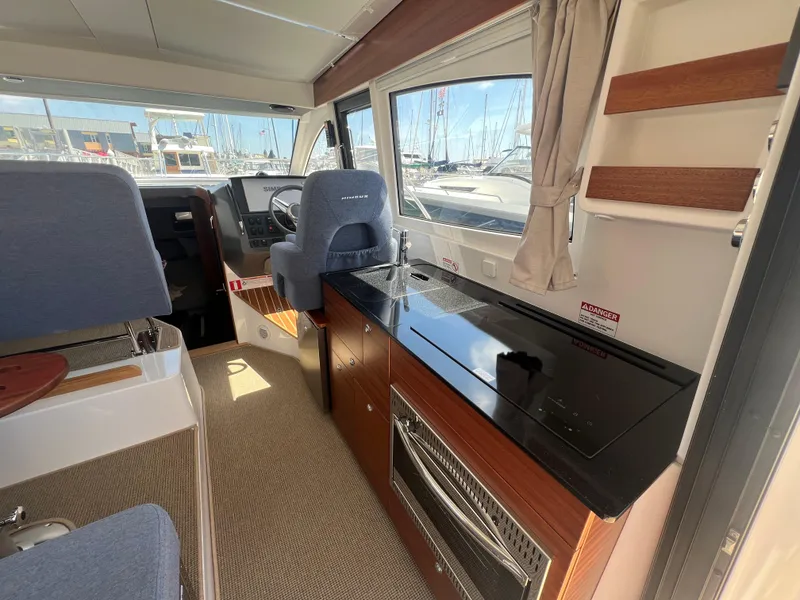 Slide: The Image of Interior of 2024 Nimbus 305 Coupe, featuring modern kitchen and helm station. - 11