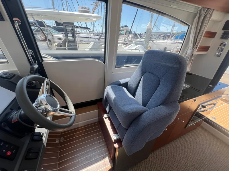 Slide: The Image of 2024 Nimbus 305 Coupe interior with steering wheel and plush captain's chair. - 16