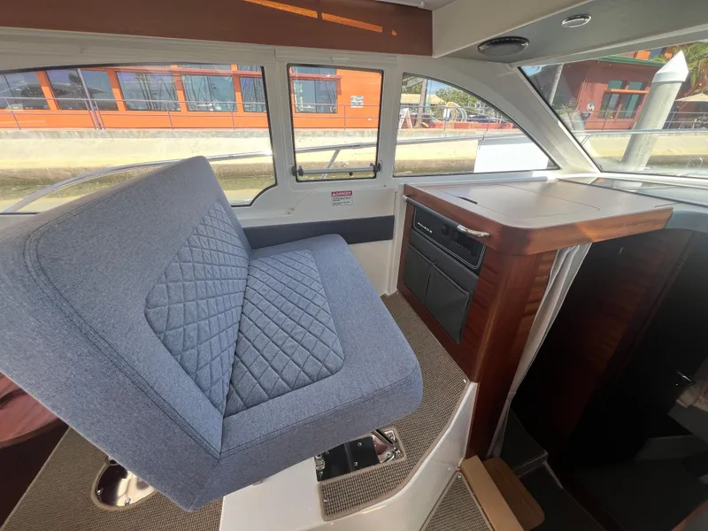 Slide: The Image of 2024 Nimbus 305 Coupe interior with blue seating and wooden accents. - 17
