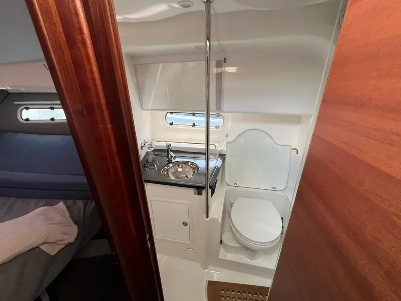 Slide: The Image of 2024 Nimbus 305 Coupe bathroom with sink, toilet, and wooden accents. - 21