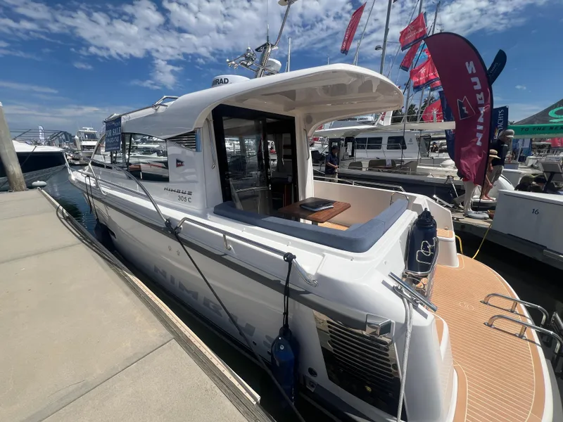 Slide: The Image of 2024 Nimbus 305 Coupe docked at a marina with other boats. - 7