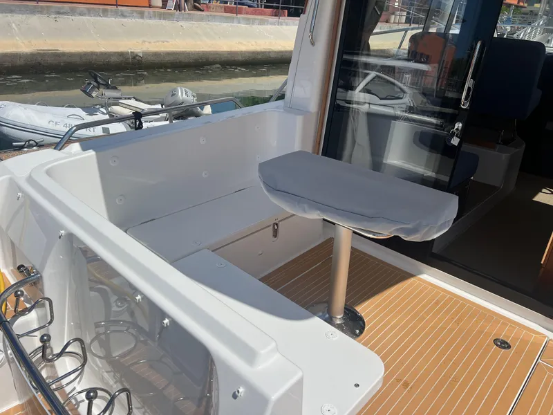 Slide: The Image of 2024 Nimbus 305 Coupe boat interior with seating and wooden flooring. - 8