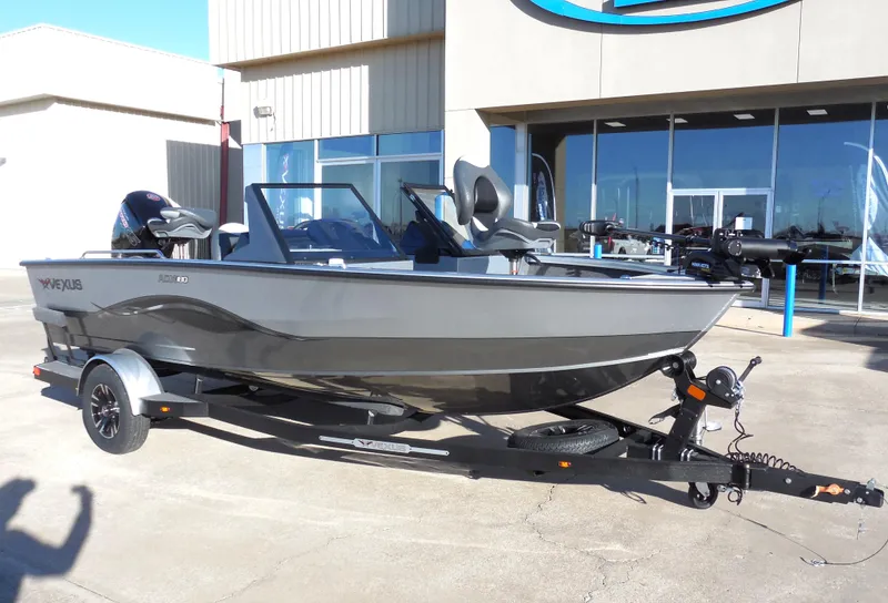 Slide: The Image of 2024 Vexus ADX 180 boat on a trailer outside a dealership. - 2