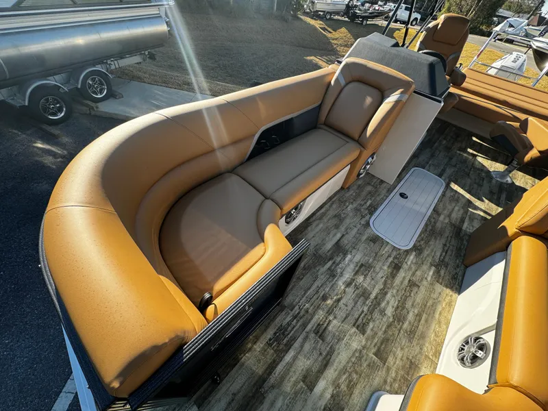 Slide: The Image of 2024 Crest Caribbean LX 230 boat interior with tan seating and wood flooring. - 12