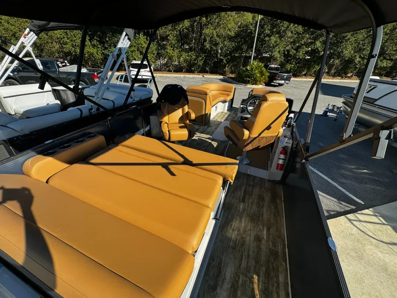 Slide: The Image of 2024 Crest Caribbean LX 230 pontoon boat with tan leather seats and spacious deck. - 6