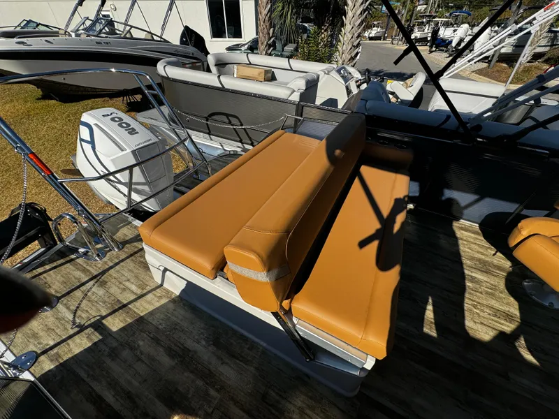 Slide: The Image of 2024 Crest Caribbean LX 230 boat with tan seating and outboard motor. - 7