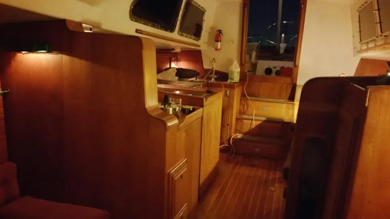 Slide: The Image of Interior of a 1967 Columbia Yacht 50 with wooden cabinetry and cozy lighting. - 12