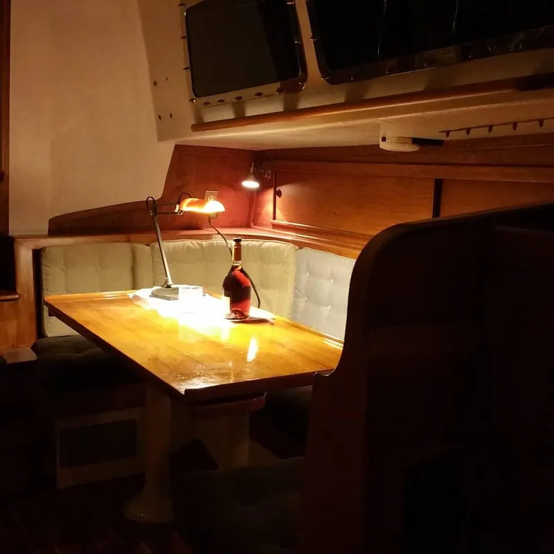 Slide: The Image of Cozy dining area inside a 1967 Columbia Yacht 50, featuring a wooden table and cushioned seating. - 15