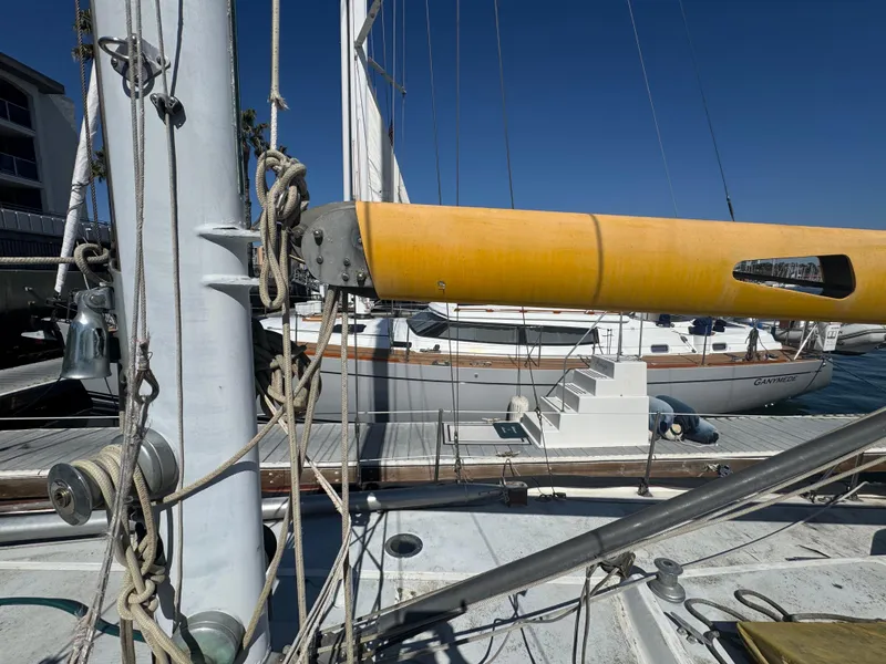 Slide: The Image of 1967 Columbia Yacht 50 with yellow boom, docked under clear blue sky. - 26