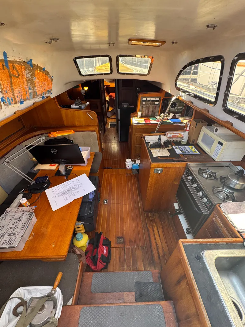 Slide: The Image of Interior of a 1967 Columbia Yacht 50, featuring a cozy cabin with kitchen and seating area. - 40