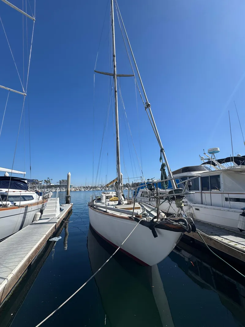 Slide: The Image of 1967 Columbia Yacht 50 docked in a marina under clear blue skies. - 49