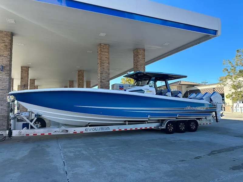 The Image of 2024 Nor-Tech 400 Supersport boat on a trailer at a gas station. - 1