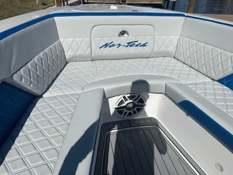 Slide: The Image of 2024 Nor-Tech 400 Supersport boat interior with white and blue diamond-stitched upholstery. - 23