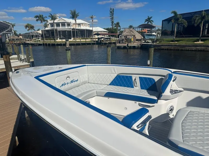 Slide: The Image of 2024 Nor-Tech 400 Supersport boat docked by waterfront homes. - 26