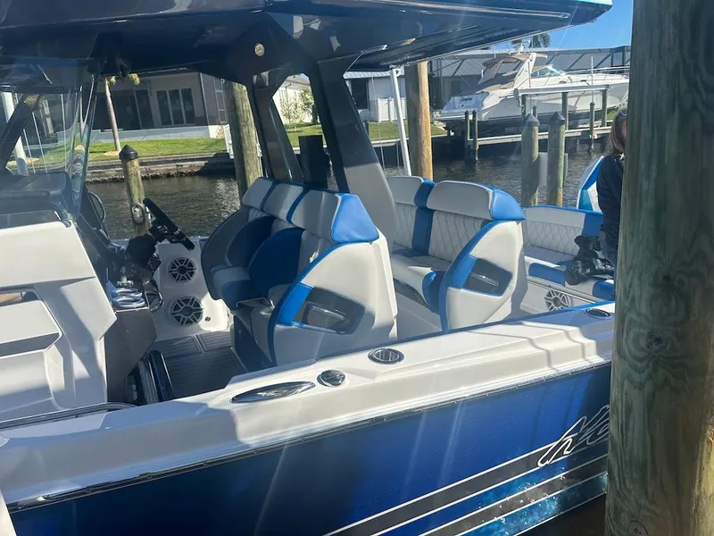 Slide: The Image of 2024 Nor-Tech 400 Supersport boat with blue and white seating at a dock. - 29