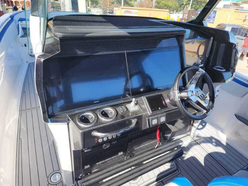 Slide: The Image of 2024 Nor-Tech 400 Supersport boat dashboard with dual screens and steering wheel. - 3