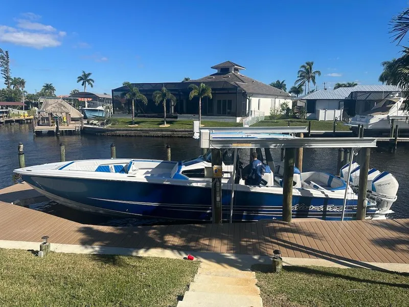 Slide: The Image of 2024 Nor-Tech 400 Supersport boat docked by a waterfront home. - 32