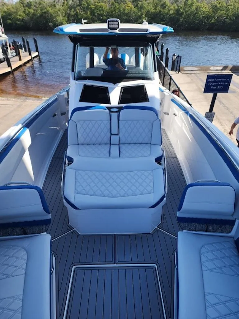 Slide: The Image of 2024 Nor-Tech 400 Supersport boat with luxurious seating and modern design at a dock. - 7