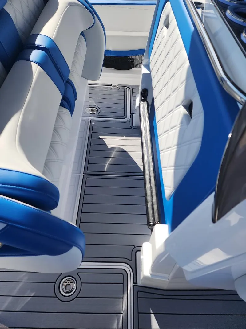 Slide: The Image of 2024 Nor-Tech 400 Supersport boat interior with blue and white seating and gray flooring. - 9