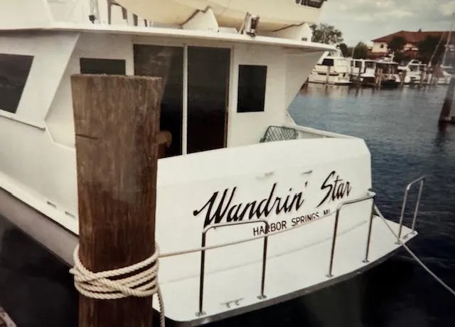 Slide: The Image of 1990 Motor Yacht 70 Brata docked, named "Wandrin' Star," in Harbor Springs marina. - 13