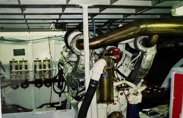Slide: The Image of Engine room of 1990 Motor Yacht 70 Brata, showcasing complex machinery and piping. - 26