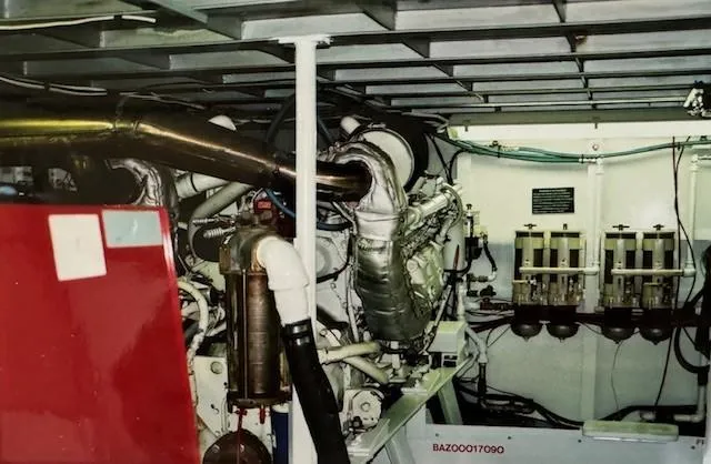 Slide: The Image of Engine room of a 1990 Motor Yacht 70 Brata, showcasing machinery and piping. - 27
