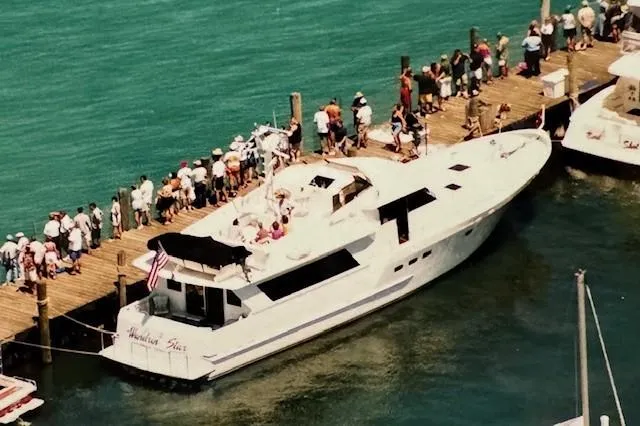 Slide: The Image of Aerial view of 1990 Motor Yacht 70 Brata docked, surrounded by people on a pier. - 3