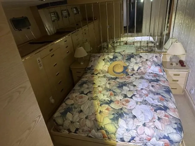 Slide: The Image of Luxurious bedroom in 1990 Motor Yacht 70 Brata with floral bedding and mirrored wall. - 36