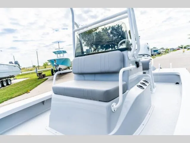 Slide: The Image of 2024 Majek Boats 18 M2 ILLUSION, sleek design, comfortable seating, modern console, outdoor setting. - 14