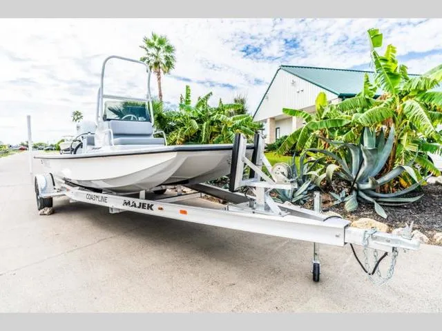 Slide: The Image of 2024 Majek Boats 18 M2 ILLUSION on trailer, surrounded by tropical plants. - 3