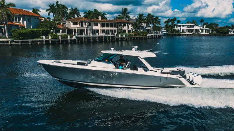 The Image of 2021 Tiara Sport 43 LS cruising on a scenic waterfront with luxury homes. - 0