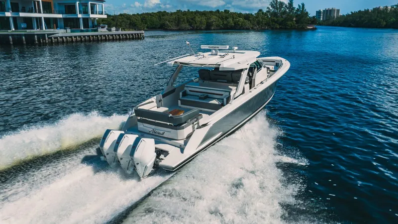 Slide: The Image of 2021 Tiara Sport 43 LS luxury boat cruising on a scenic waterway. - 2