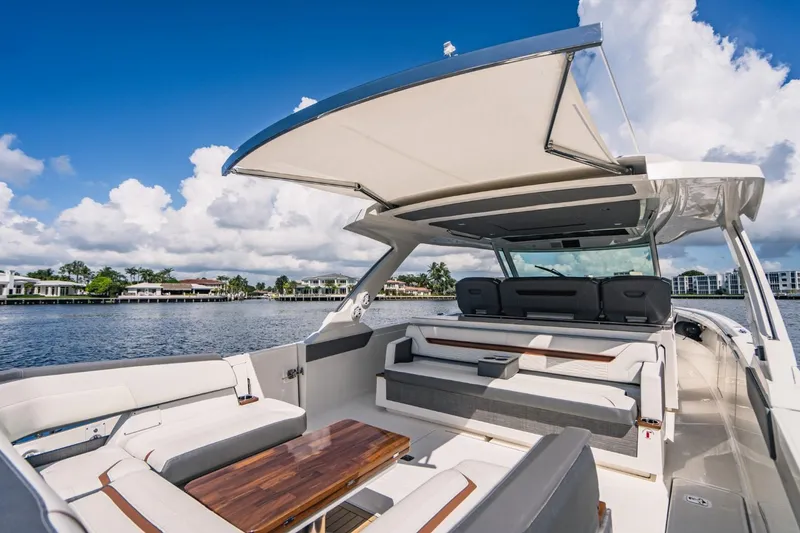 Slide: The Image of 2021 Tiara Sport 43 LS luxury boat interior with seating and table on a sunny day. - 32