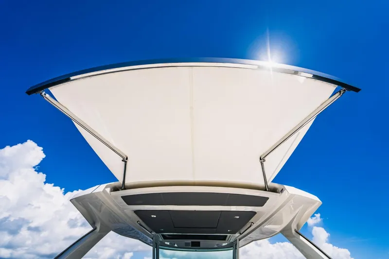 Slide: The Image of Tiara Sport 43 LS 2021 boat canopy against blue sky and clouds. - 34